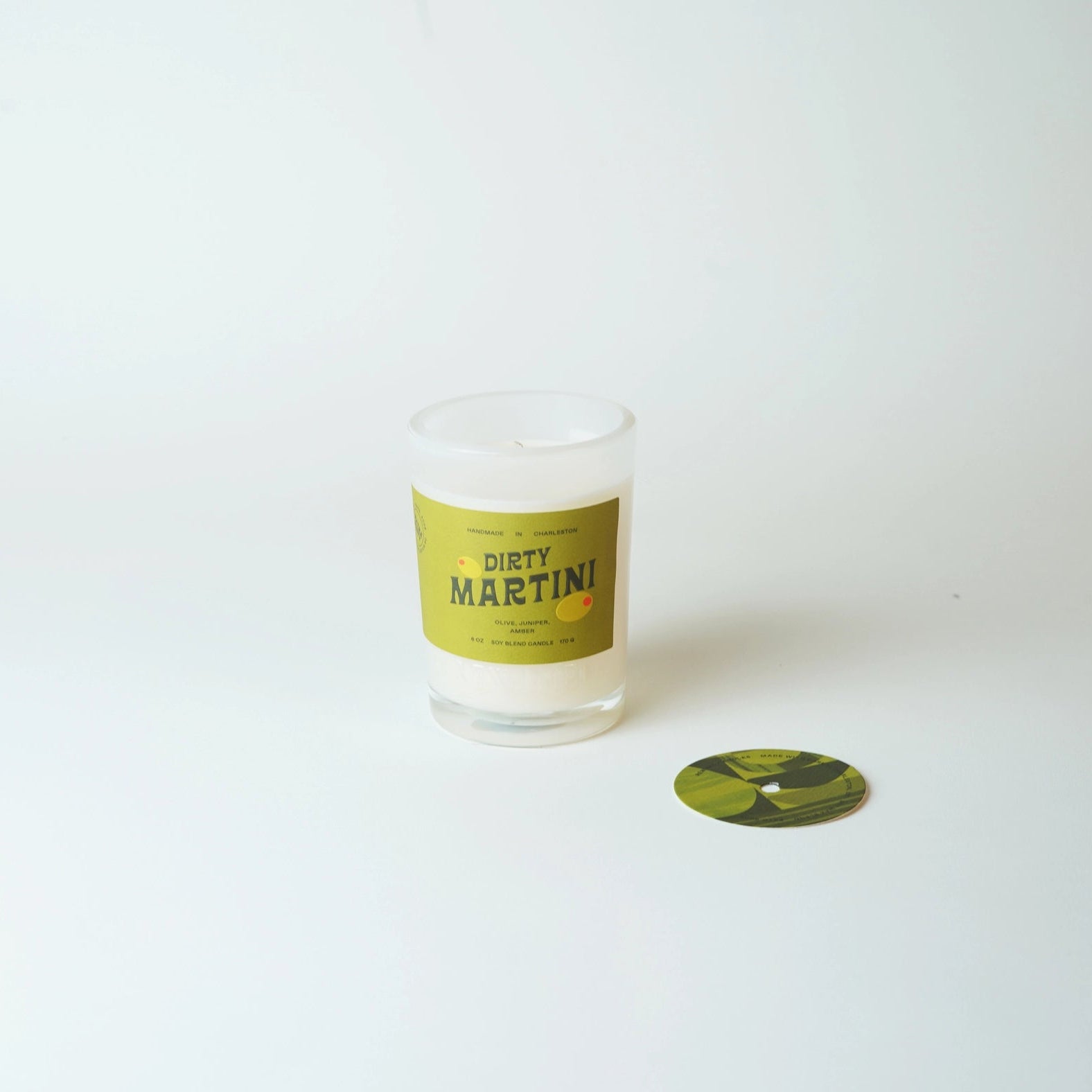 Candle with 'Dirty Martini' label on a white background